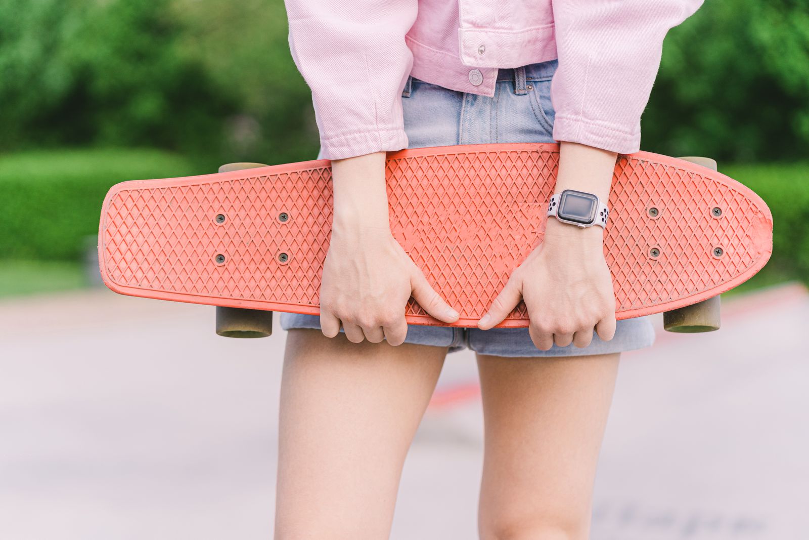Pink skateboard held outdoors